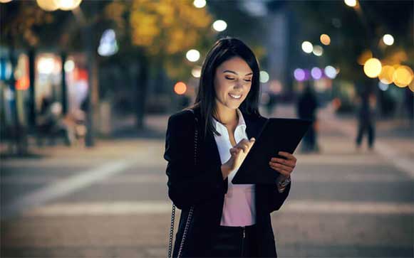 Een vrouw gebruikt haar tablet op straat