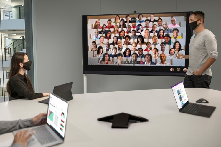 Für Teams entwickelt, um sich zu besprechen und zusammenzuarbeiten, wo auch immer sie arbeiten Man and Woman wearing masks working with Surface Hub 2S 85"